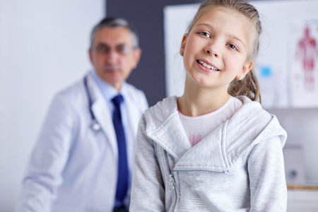 Portrait of a cute little girl and her doctor at hospitalの写真素材