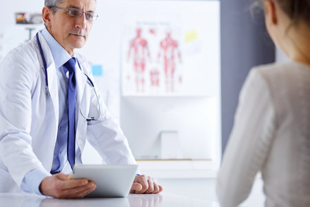 Doctor man with patient in medical officeの写真素材