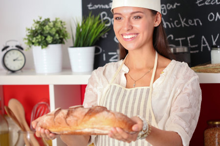 Young woman sitting a table in the kitchen. Young womanの写真素材