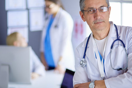 Portrait of a smiling doctor in his bright officeの写真素材