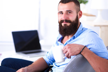 Young businessman sitting on chair in officeの写真素材