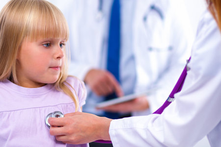 Doctor woman examining a little girl at hospitalの写真素材
