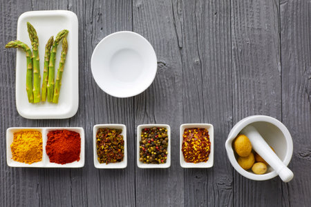 Fresh asparagus served on white plate with rustic wooden table background, top view.の写真素材