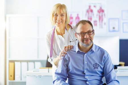 doctor talking to her male patient at officeの写真素材