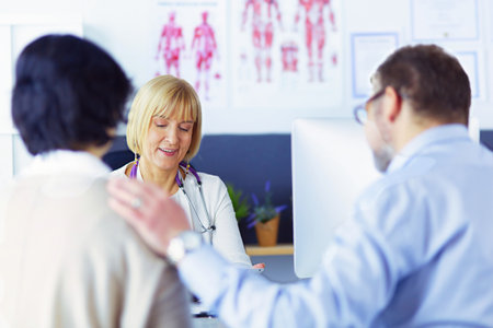 doctor talking to her male patient at officeの写真素材