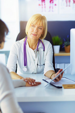 doctor explaining diagnosis to her female patientの写真素材
