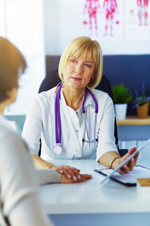 doctor explaining diagnosis to her female patientの写真素材