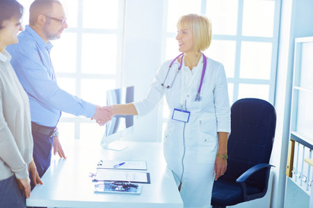Female doctor handshaking a patients hand and smilingの写真素材