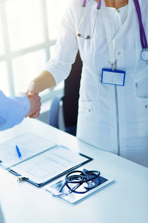 Female doctor handshaking a patients hand and smilingの写真素材