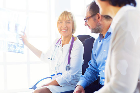 Doctor woman explaining x-ray results to patientの写真素材