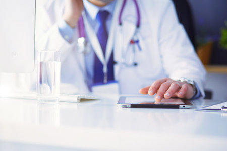 Portrait of senior doctor in office sitting at the deskの写真素材
