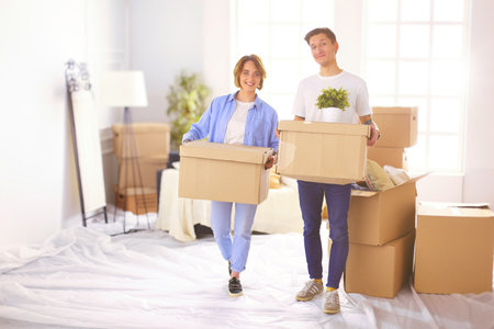 A girl and a guy holding boxes for moving the hands and looking inside boxの写真素材