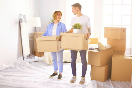 Couple holding boxes for moving the hands and looking inside boxの写真素材