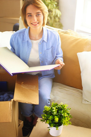 Young woman moving out and packing cardboard boxの写真素材