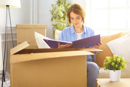 Young woman moving out and packing cardboard boxの写真素材