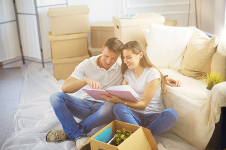 Happy young couple unpacking or packing boxes and moving into a new homeの写真素材