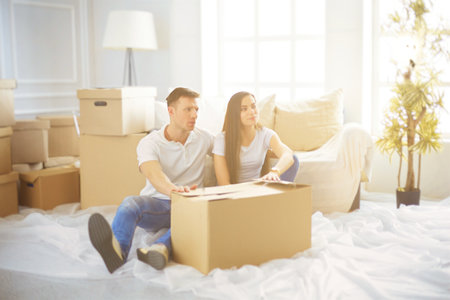 Happy young couple unpacking boxes in their new homeの写真素材