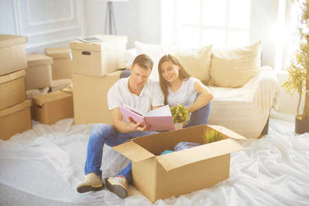 Happy young couple unpacking or packing boxes and moving into a new homeの写真素材