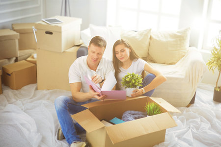 Happy young couple unpacking or packing boxes and moving into a new homeの写真素材