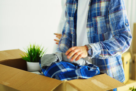 A just married couple unpacking boxes and moving into a new home. Positive emotion.の写真素材