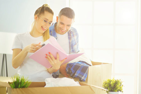 A just married couple unpacking boxes and moving into a new home. Positive emotion.の写真素材