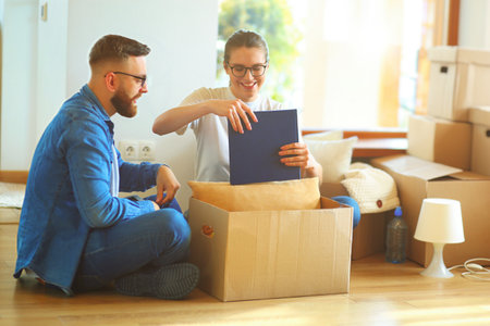 Cute couple unpacking cardboard boxes in their new homeの写真素材