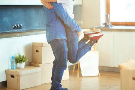Happy couple hugging in their new houseの写真素材