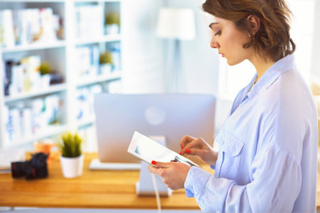 Portrait of an attractive professional photographer woman and using a tabletの写真素材