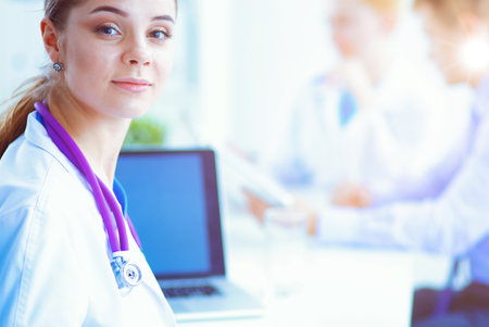 Attractive female doctor in front of medical group.の写真素材