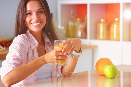Young woman sitting a table in the kitchen. Young womanの写真素材