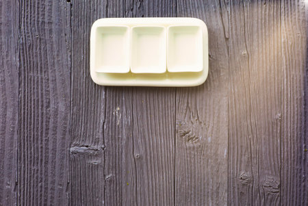 Square shaped empty ceramic plates on wooden table background, top view.の写真素材