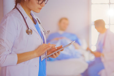 Female doctor using tablet computer in hospital lobbyの写真素材
