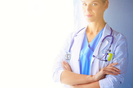 Portrait of young woman doctor with white coat standing in hospitalの写真素材
