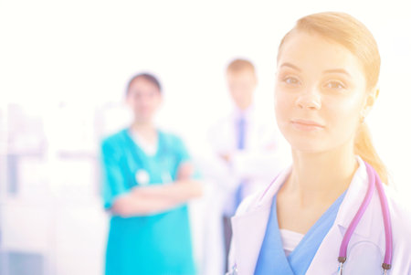 Attractive female doctor in front of medical group.の写真素材