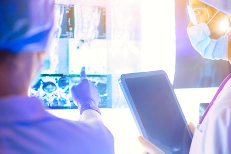 Two female women medical doctors looking at x-rays in a hospitalの写真素材