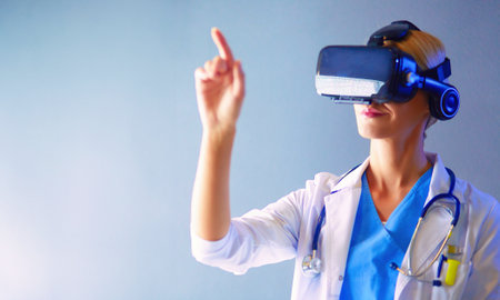 Female doctor wearing virtual reality glasses isolated on white backgroundの写真素材