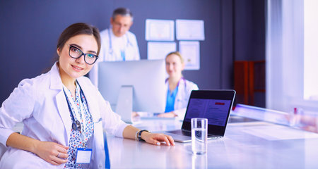 Serious medical team using a laptop in a bright officeの写真素材