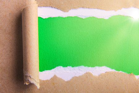 Grey package paper torn to reveal green panel ideal for copy space.の写真素材
