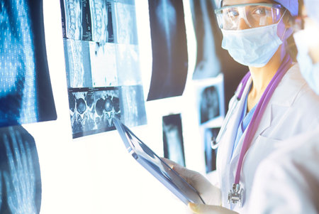 Two female women medical doctors looking at x-rays in a hospital.の写真素材