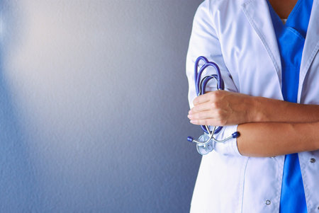 Portrait of young woman doctor with white coat standing in hospital.の写真素材