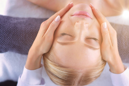 Young woman lying on a massage table,relaxing with eyes closed. Woman. Spa salonの写真素材