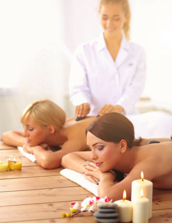 Two young beautiful women relaxing and enjoying at the spa centerの写真素材