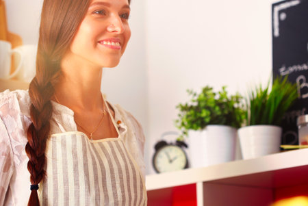 Young woman sitting a table in the kitchen. Young womanの写真素材
