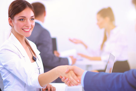 Business people shaking hands, finishing up a meeting, in officeの写真素材
