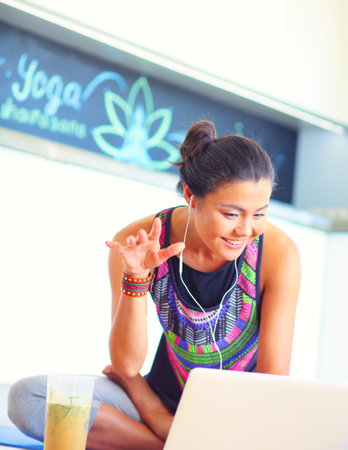 Sporty smiling woman using laptop in bright room. Woman. Lifestyleの写真素材