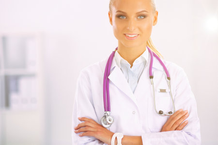 Portrait of young woman doctor with white coat standing in hospitalの写真素材