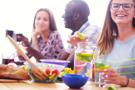 Top view of group of people having dinner together while sitting at wooden table. Food on the table. People eat fast food.の写真素材