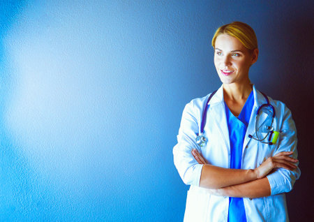 Portrait of young woman doctor with white coat standing in hospital.の写真素材