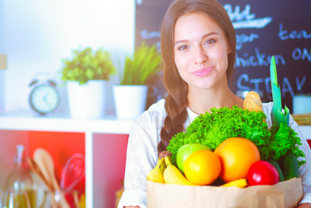 Young woman holding grocery shopping bag with vegetables. Young womanの写真素材