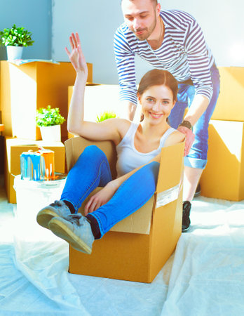 Happy young couple unpacking or packing boxes and moving into a new home. young coupleの写真素材